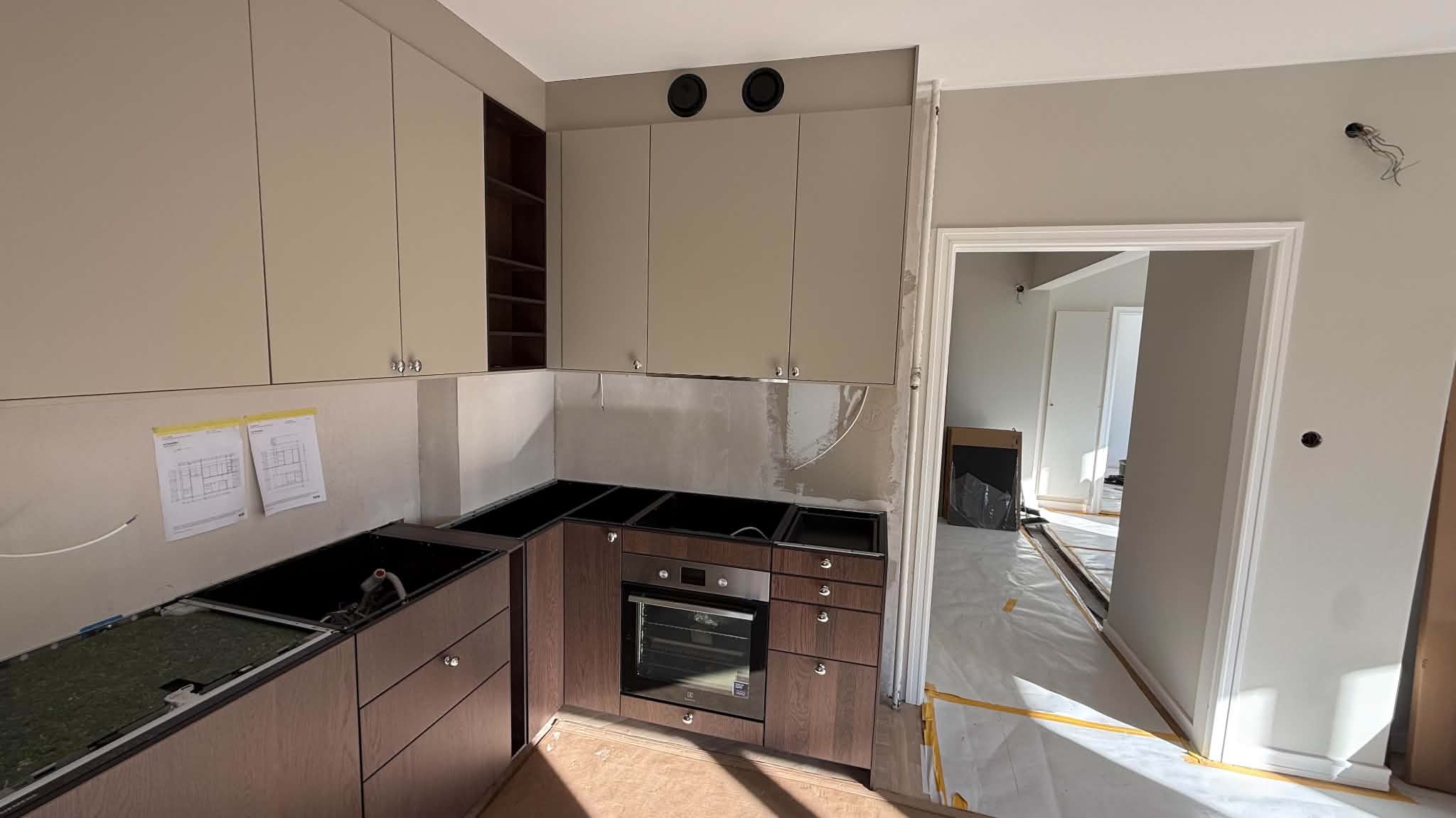 Svart bänkskiva monteras i vinkel runt inbyggnadsugn under köksrenovering