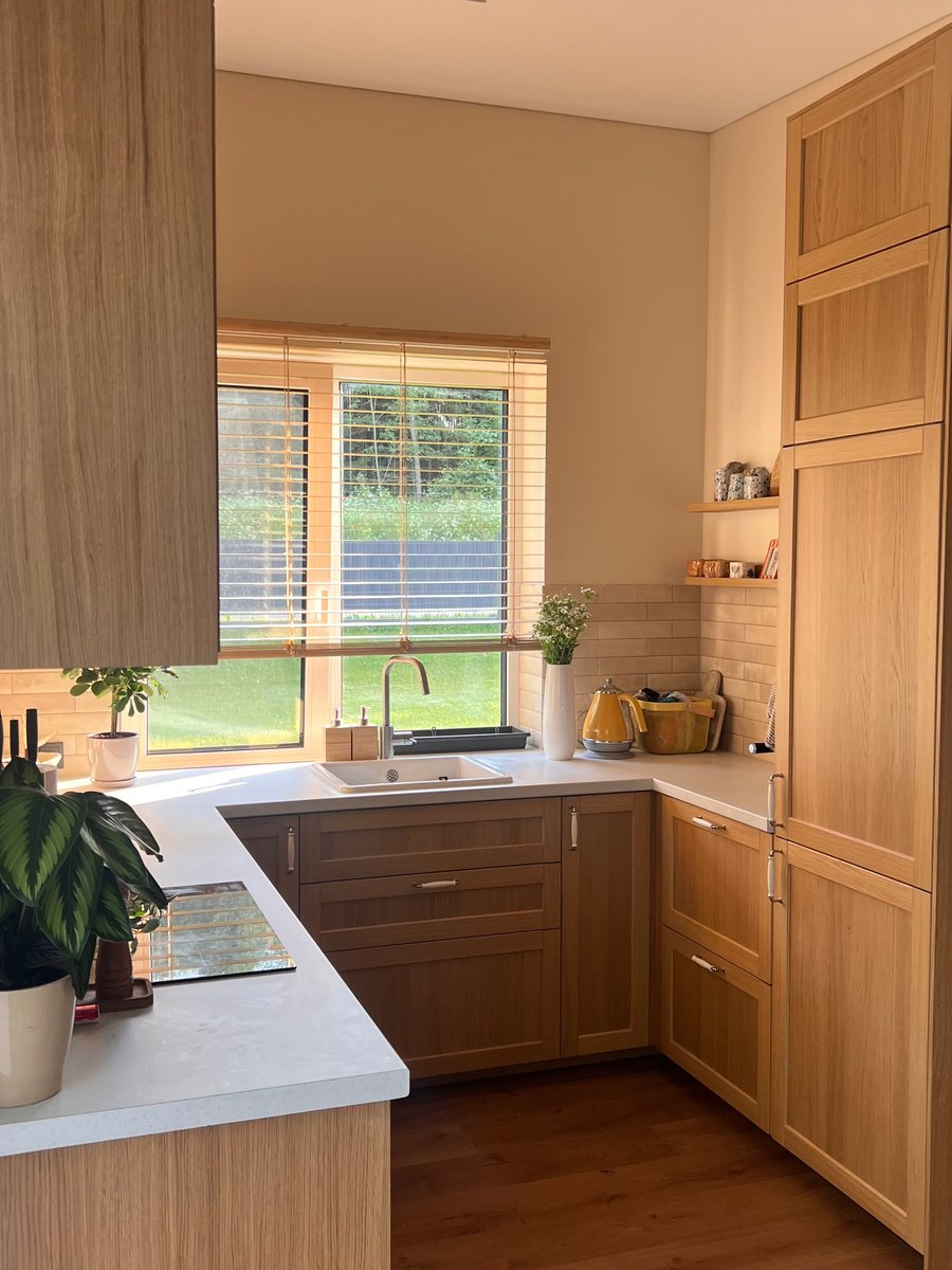 Färdigt kök efter renovering med träskåp, bänkskiva och fönster